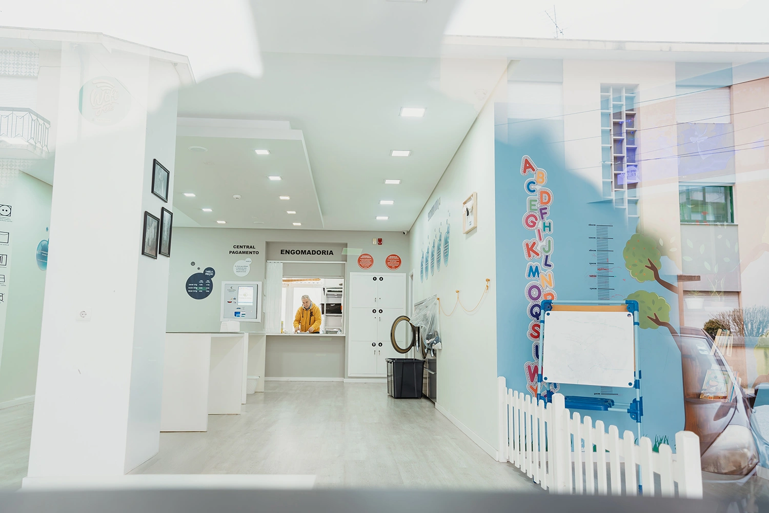 Vista interior da Lavandaria Self-Service espaçosa e bem iluminada, mostrando ambiente limpo e organizado para uma experiência de lavagem agradável